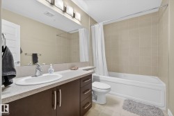 Bathroom featuring vanity, shower / bath combo with shower curtain, and light tile patterned floors - 