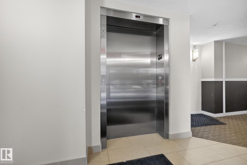 Elevator with carpet and baseboards - 104 8515 99 Street, Edmonton, AB - Indoor Photo Showing Other Room