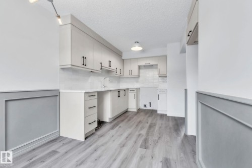 Laundry room featuring light wood-type flooring and a textured ceiling - 1281 Hooke Road, Edmonton, AB - Indoor Photo Showing Kitchen