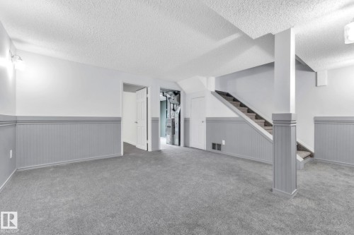 Below grade area with a wainscoted wall, a textured ceiling, and carpet flooring - 1281 Hooke Road, Edmonton, AB - Indoor Photo Showing Other Room