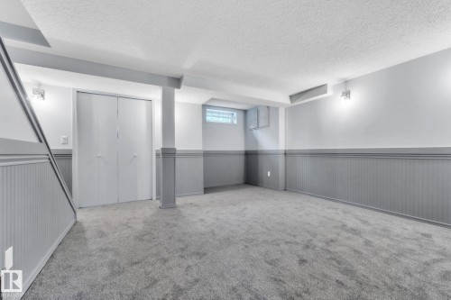 Below grade area with a textured ceiling, a wainscoted wall, and carpet floors - 1281 Hooke Road, Edmonton, AB - Indoor