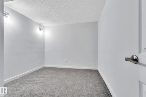 Carpeted empty room featuring baseboards and a textured ceiling - 1281 Hooke Road, Edmonton, AB - Indoor Photo Showing Other Room