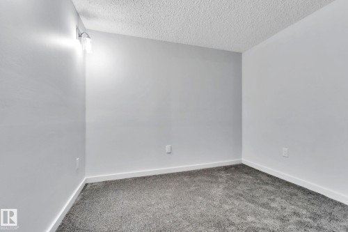 Carpeted spare room featuring a textured ceiling - 1281 Hooke Road, Edmonton, AB - Indoor Photo Showing Other Room