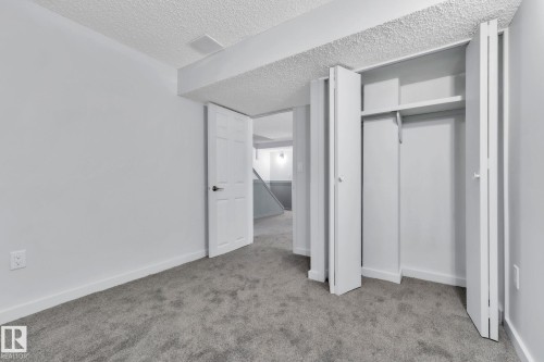 Unfurnished bedroom featuring light carpet, a textured ceiling, and a closet - 1281 Hooke Road, Edmonton, AB - Indoor Photo Showing Other Room