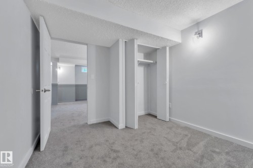 Unfurnished bedroom featuring light colored carpet, a textured ceiling, and a closet - 1281 Hooke Road, Edmonton, AB - Indoor Photo Showing Other Room