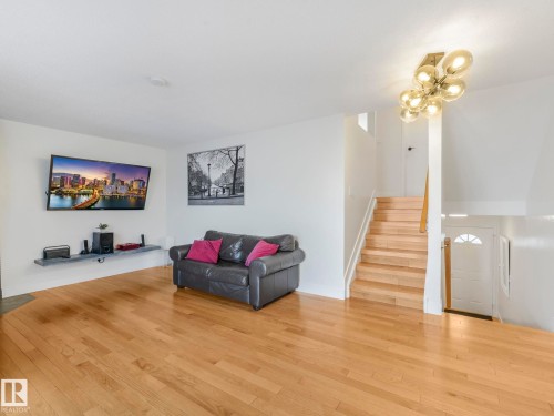 Living room with wood finished floors and suspended lighting - 61 9520 174 Street, Edmonton, AB - Indoor Photo Showing Other Room