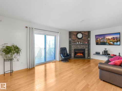 Living area with light wood finished floors and a fireplace - 61 9520 174 Street, Edmonton, AB - Indoor Photo Showing Living Room With Fireplace