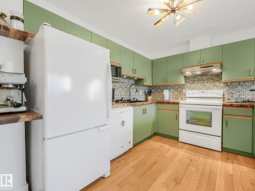 Kitchen featuring green cabinets, white appliances, light wood finished floors, and wooden counters - 61 9520 174 Street, Edmonton, AB - Indoor Photo Showing Kitchen