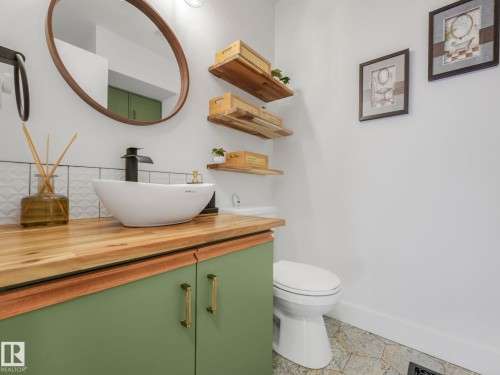 Half bath with vanity and decorative backsplash - 61 9520 174 Street, Edmonton, AB - Indoor Photo Showing Bathroom