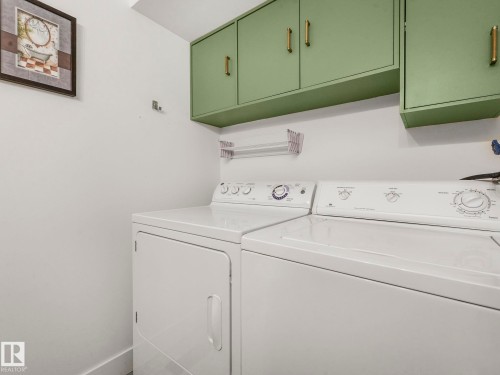 Laundry room featuring washer and clothes dryer and cabinet space - 61 9520 174 Street, Edmonton, AB - Indoor Photo Showing Laundry Room