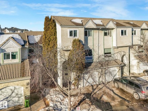 Rear view of property featuring stucco siding, a tile roof, a balcony, and solar panels - 61 9520 174 Street, Edmonton, AB - Outdoor