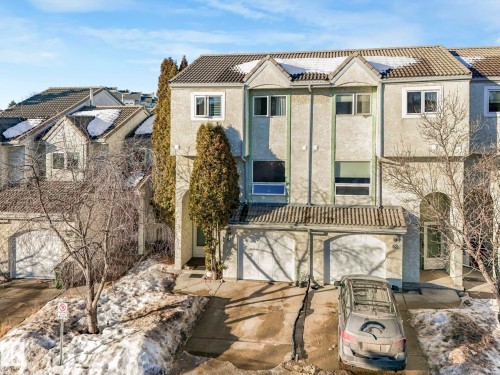 View of front facade with stucco siding, a tile roof, driveway, a garage, and solar panels - 61 9520 174 Street, Edmonton, AB - Outdoor