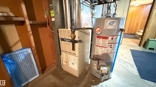Utility room featuring gas water heater and heating unit - 4608 102 Avenue, Edmonton, AB - Indoor Photo Showing Basement