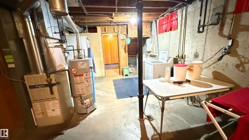 Unfinished basement with gas water heater and washing machine and clothes dryer - 4608 102 Avenue, Edmonton, AB - Indoor Photo Showing Basement