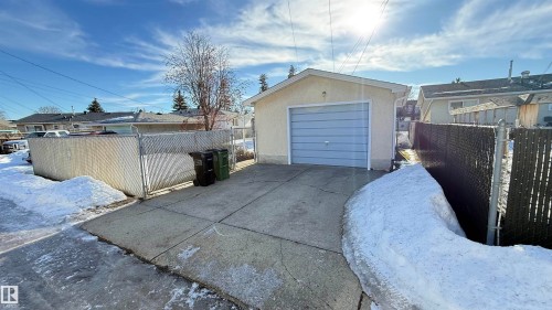 Snow covered garage with concrete driveway and a detached garage - 4608 102 Avenue, Edmonton, AB - Outdoor