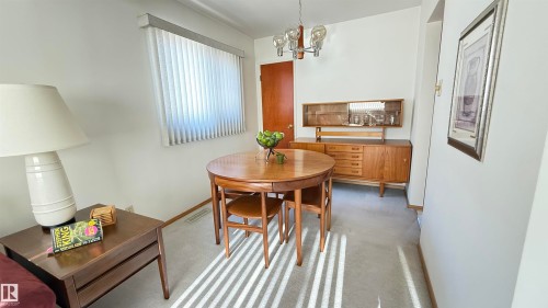 Dining space featuring carpet flooring and suspended lighting - 4608 102 Avenue, Edmonton, AB - Indoor