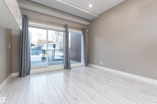 Living room featuring light wood-style flooring and baseboards - 105 10006 83 Avenue, Edmonton, AB - Indoor Photo Showing Other Room