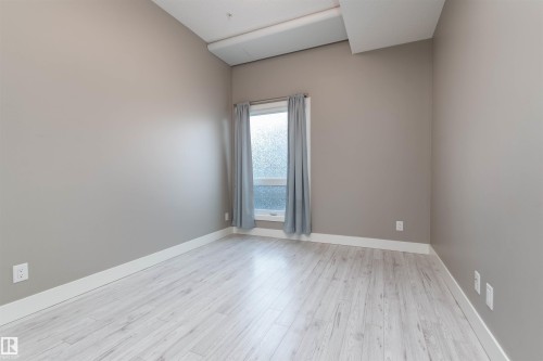 Bedroom featuring light wood-style flooring and baseboards - 105 10006 83 Avenue, Edmonton, AB - Indoor Photo Showing Other Room