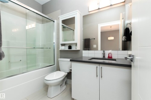 Full bath featuring vanity and enclosed tub / shower combo - 105 10006 83 Avenue, Edmonton, AB - Indoor Photo Showing Bathroom