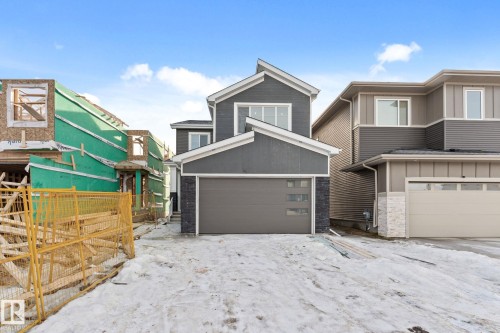 View of front of house with a garage, stone siding, and board and batten siding - 3 Pierwyck Loop, Spruce Grove, AB - Outdoor