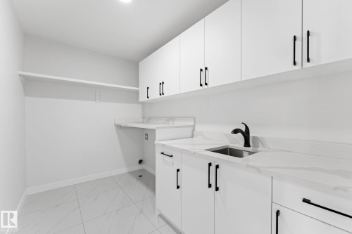 Laundry room featuring cabinet space and light marble finish flooring - 3 Pierwyck Loop, Spruce Grove, AB - Indoor Photo Showing Kitchen