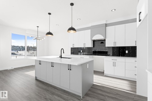 Kitchen featuring white cabinets, tasteful backsplash, and dark wood-style flooring - 3 Pierwyck Loop, Spruce Grove, AB - Indoor Photo Showing Kitchen With Upgraded Kitchen