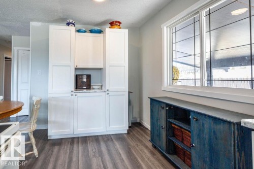 Kitchen with white cabinetry, white stove, a textured ceiling, and dark wood-style floors - 4628 46 Ave, Evansburg, AB - Indoor