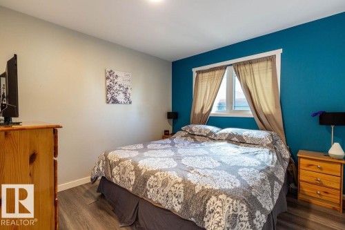 Bedroom with dark wood finished floors and baseboards - 4628 46 Ave, Evansburg, AB - Indoor Photo Showing Bedroom