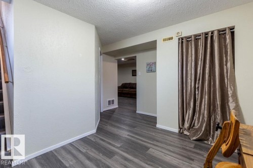 Empty room featuring dark wood-style floors and a textured ceiling - 4628 46 Ave, Evansburg, AB - Indoor Photo Showing Other Room