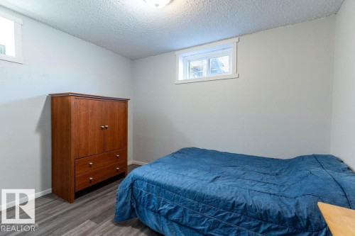 Bedroom featuring a textured ceiling and wood finished floors - 4628 46 Ave, Evansburg, AB - Indoor Photo Showing Bedroom
