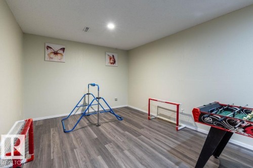 Playroom featuring dark wood-style floors and baseboards - 4628 46 Ave, Evansburg, AB - Indoor