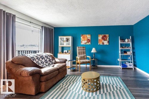Living area featuring wood finished floors and a textured ceiling - 4628 46 Ave, Evansburg, AB - Indoor Photo Showing Living Room