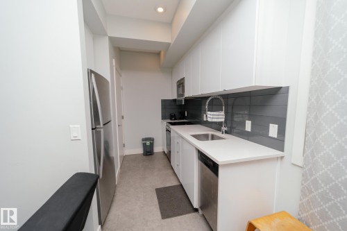 Kitchen with white cabinetry, stainless steel appliances, modern cabinets, light stone counters, and recessed lighting - 70 446 Allard Boulevard, Edmonton, AB - Indoor Photo Showing Kitchen