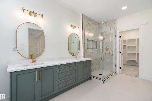 Full bathroom with a spacious closet, a marble finish shower, double vanity, and light tile patterned floors - Edmonton, AB - Indoor Photo Showing Bathroom