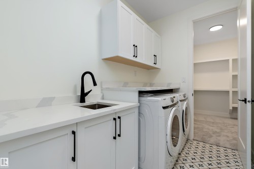 Laundry room featuring cabinet space and washer and clothes dryer - Edmonton, AB - Indoor Photo Showing Laundry Room