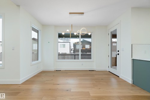 Unfurnished dining area featuring a chandelier and light wood-style floors - Edmonton, AB - Indoor Photo Showing Other Room