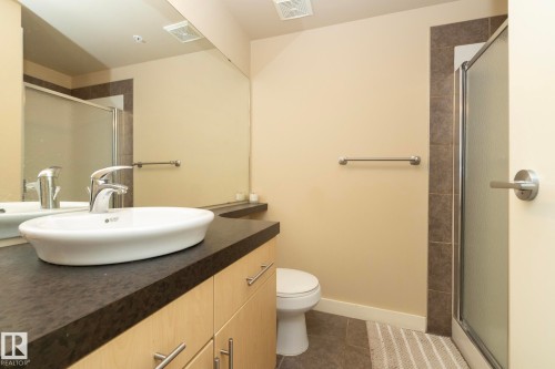 Full bath with a shower stall, vanity, and dark tile patterned flooring - 1004 10136 104 Street, Edmonton, AB - Indoor Photo Showing Bathroom