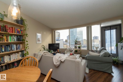 Living area featuring wood finished floors and a baseboard heating unit - 1004 10136 104 Street, Edmonton, AB - Indoor Photo Showing Living Room