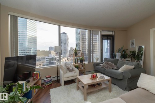 Living area with wood finished floors and a baseboard heating unit - 1004 10136 104 Street, Edmonton, AB - Indoor Photo Showing Living Room
