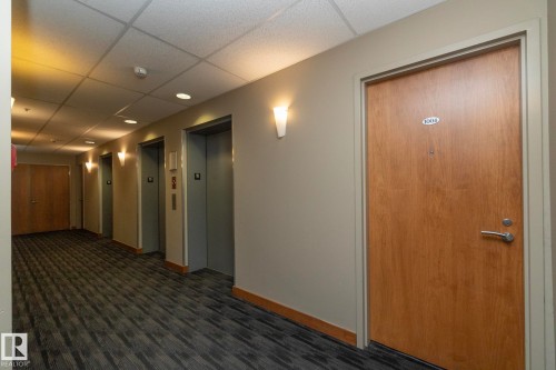 Hallway with a drop ceiling, elevator, and dark wood-style floors - 1004 10136 104 Street, Edmonton, AB - Indoor Photo Showing Other Room