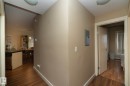 Hallway featuring dark wood-type flooring, a textured ceiling, electric panel, and a baseboard heating unit - 1004 10136 104 Street, Edmonton, AB  - Indoor Photo Showing Other Room 
