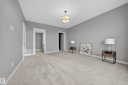 Bedroom featuring baseboards and light carpet - 