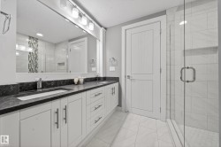 Bathroom featuring double vanity, a shower stall, and a textured ceiling - 