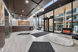 Lobby with floor to ceiling windows, recessed lighting, a high ceiling, and wainscoting - 