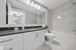Bathroom with vanity and bathtub / shower combination - 