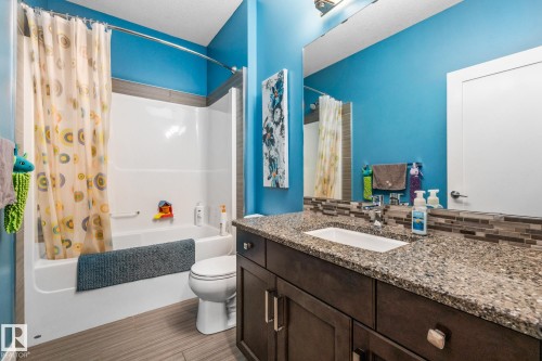 Full bath with vanity, shower / bathtub combination with curtain, and decorative backsplash - 14 Spring Bay, Spruce Grove, AB - Indoor Photo Showing Bathroom