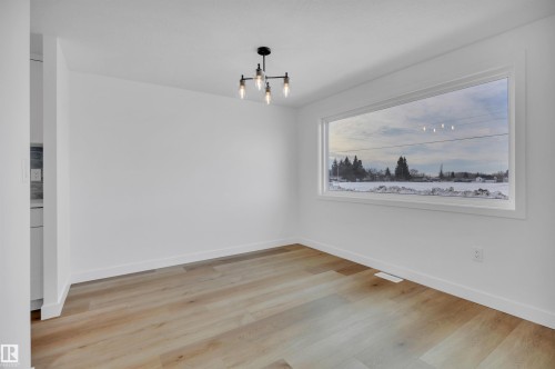 Unfurnished dining area with light wood-type flooring and a chandelier - 5021 46 Avenue, Calmar, AB - Indoor Photo Showing Other Room