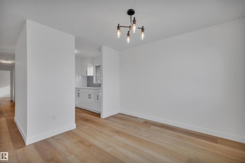 Unfurnished dining area with light wood-type flooring and a chandelier - 5021 46 Avenue, Calmar, AB - Indoor Photo Showing Other Room