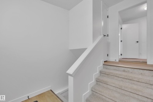 Stairs featuring wood finished floors and baseboards - 5021 46 Avenue, Calmar, AB - Indoor Photo Showing Other Room