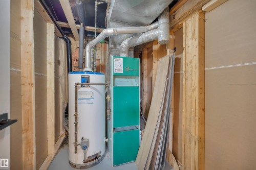 Utility room featuring gas water heater and heating unit - 5021 46 Avenue, Calmar, AB - Indoor Photo Showing Basement